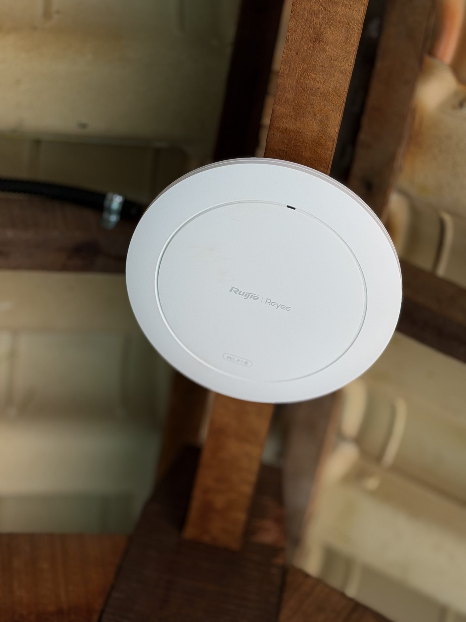 Access Point Wi-Fi Ruijie Reyee instalado em viga de madeira em ambiente interno